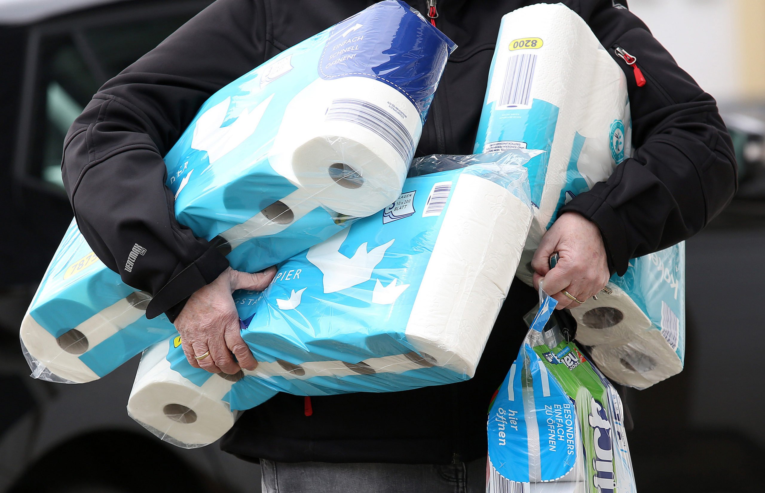 A shopper holds toilet roll and kitchen paper at the start of the pandemic in March 2020 when Germans were urged not to panic buy.