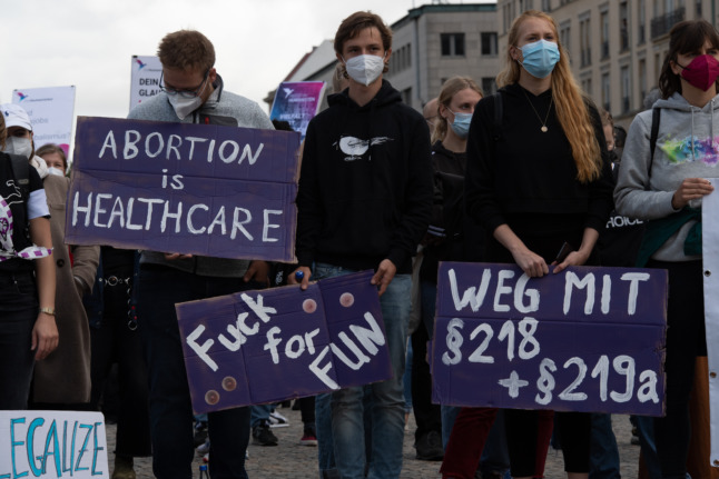 Counter-protesters hold posters opposing the "March for Life" demo in Berlin in September 2021.