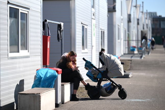 A woman with a pram sits in a reception centre for refugees from Ukraine in Leipzig. 