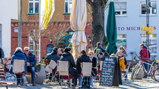 People eat and drink outdoors in Lübbenau, Brandenburg. Germany is set to ease Covid measures, but infections are rising.