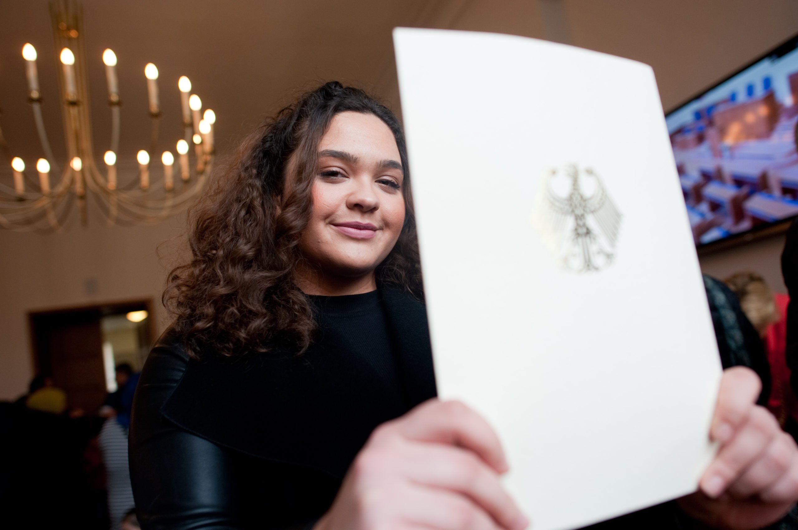 A woman shows the booklet with her naturalisation certificate at Neukölln town hall in Berlin in April 2016.