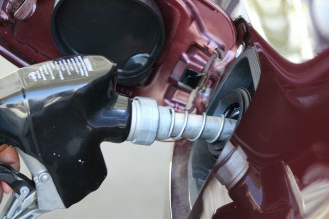 A petrol pump filling up a fuel tank.