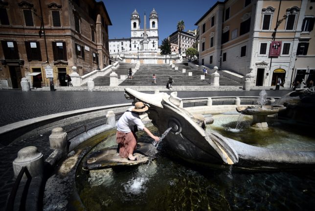 A tourist cools off at the Barcaccia fountain by the Spanish Steps in central Rome.
