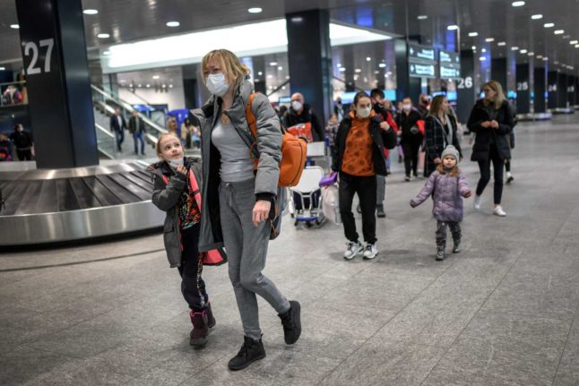 Ukrainian refugees walk at Zurich Airport after landing from Krakow in a plane chartered by a Swiss millionaire at Zurich Airport, on March 22, 2022. Photo: FABRICE COFFRINI / AFP