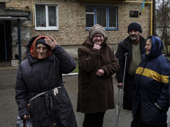 Women cry outside their houses in Bucha near Kyiv