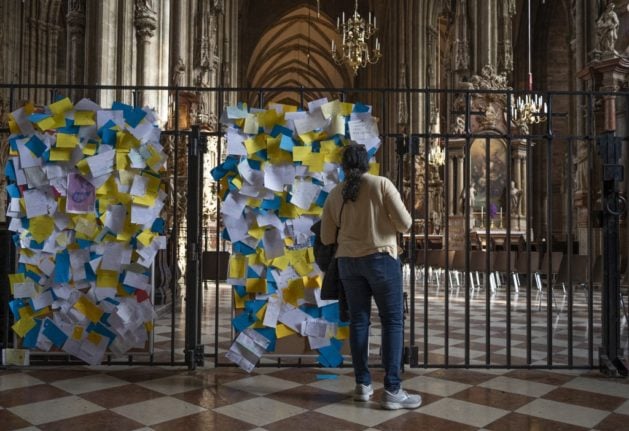 A woman reads notes supporting Ukraine during the war with Russia at Saint Stephen's cathedral in Vienna