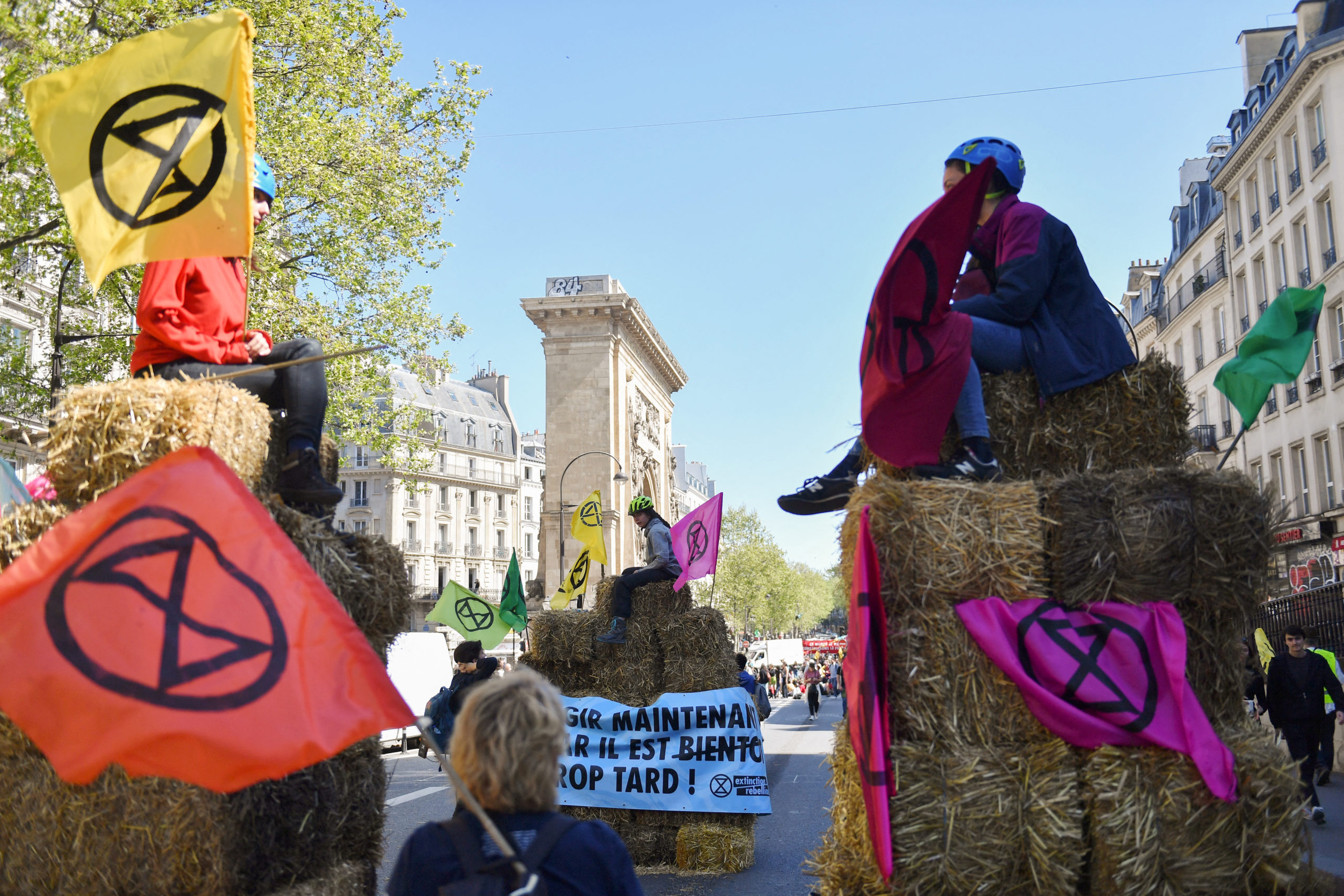 Extinction Rebellion activists hold placards with the logo at a protest in Paris