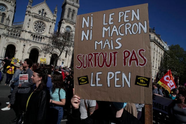 A protestor holds a placard which translates as 'nor Macron, nor Le Pen - but especially not Le Pen'
