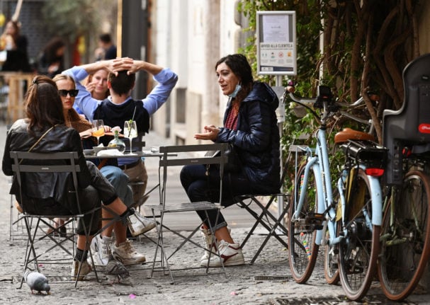 People enjoy an aperitivo in downtown Rome. 