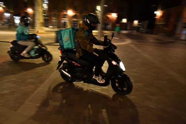 A Deliveroo food delivery driver on a scooter