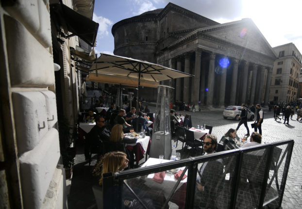 People eat at a restaurant by the Pantheon in downtown Rome.