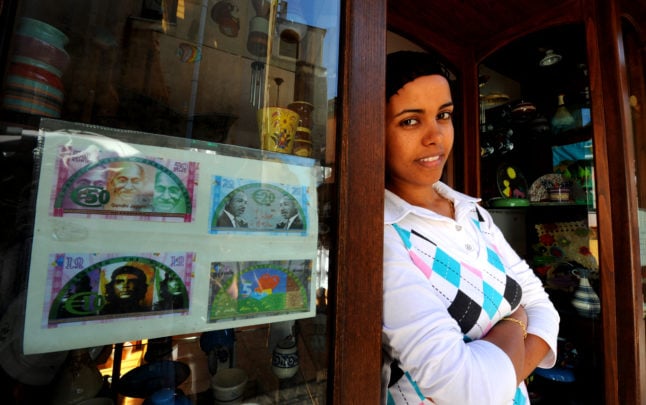 A woman originally from Ethiopia stands outside a shopfront in Riace on June 22, 2011.