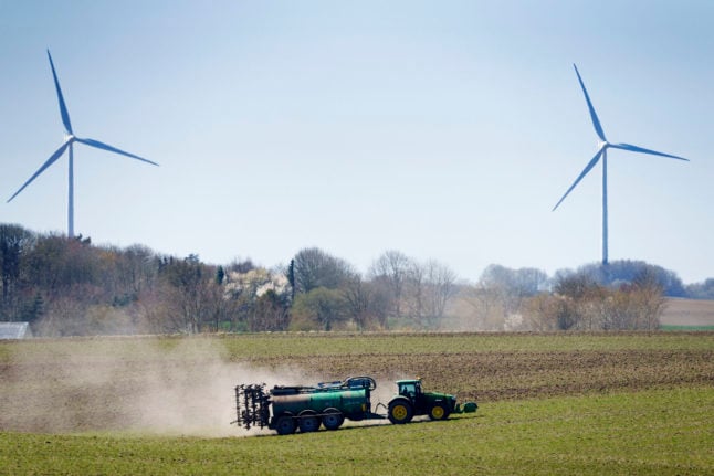 a tractor with wind turbines in the background