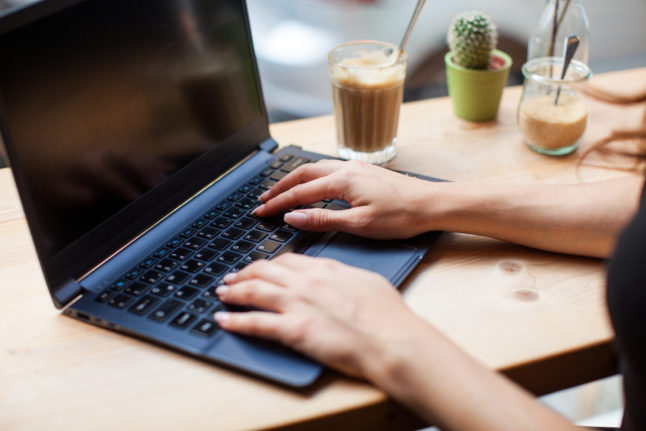 A freelancer works on a laptop in a cafe in Hamburg