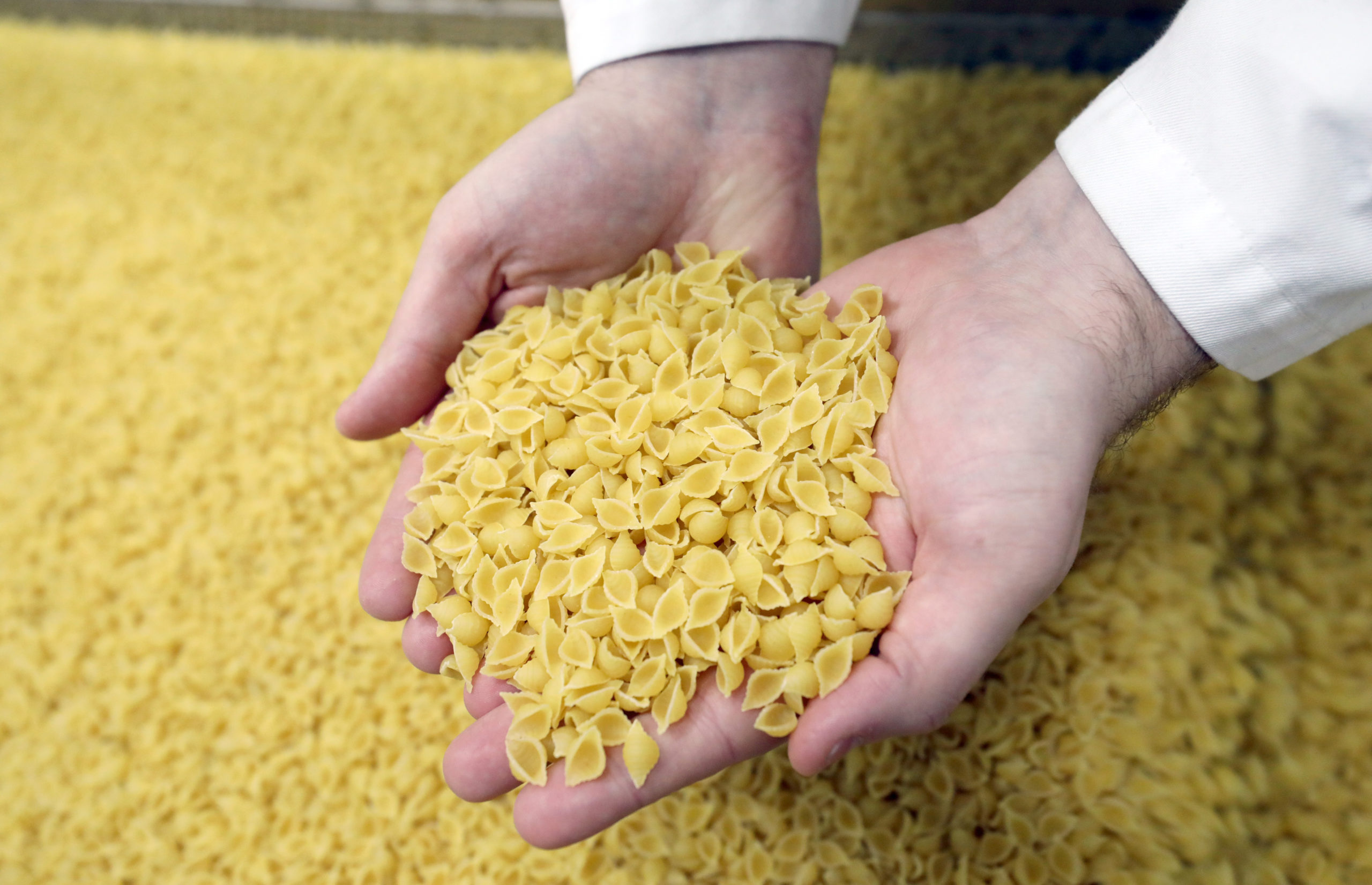 An employee checks soup pasta at a pasta manufacturer's factory. 