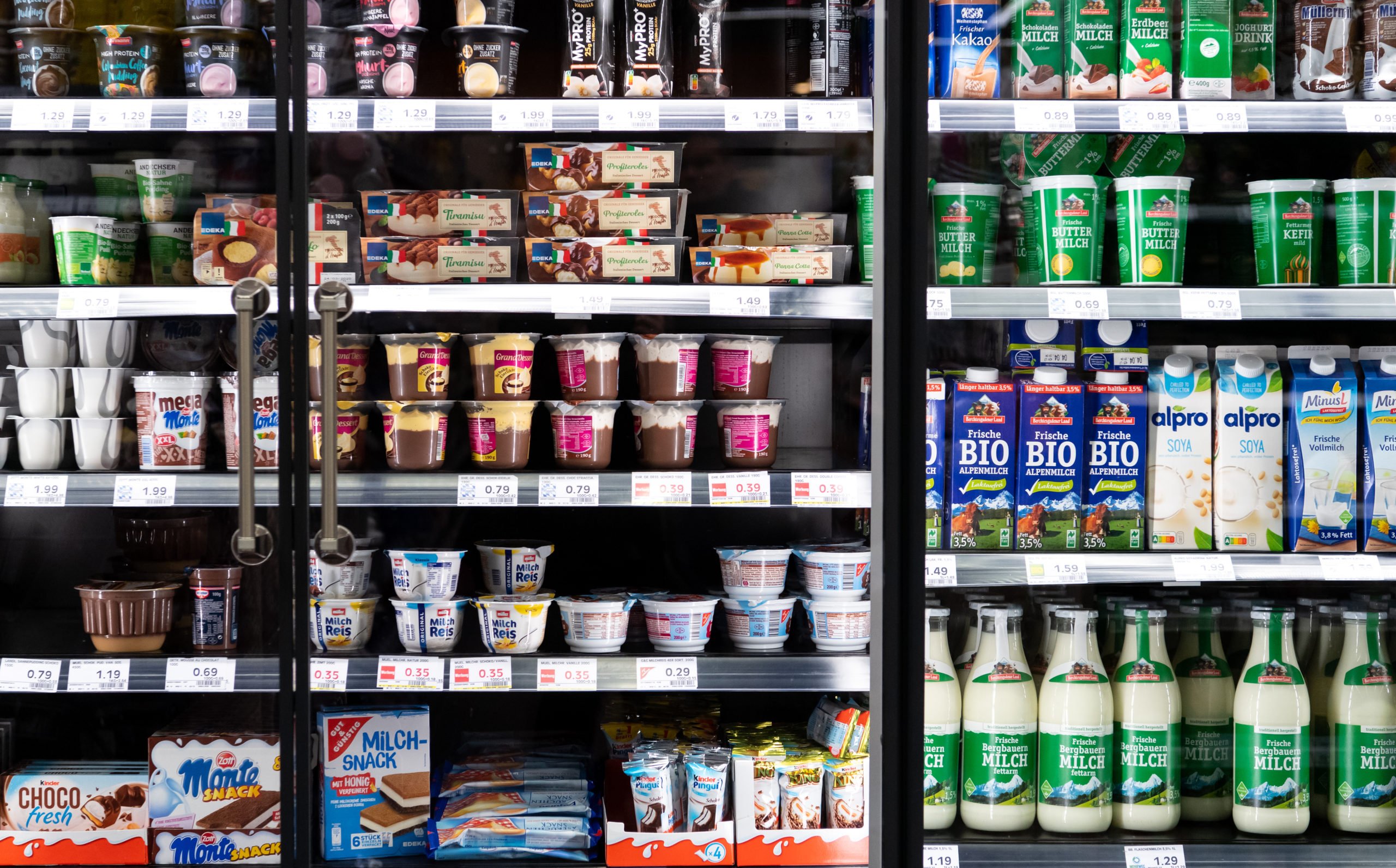 Dairy products from different manufacturers on a supermarket shelf.