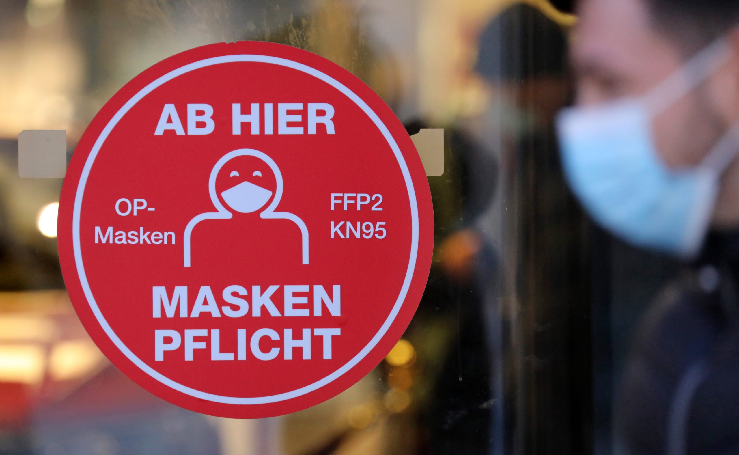 A sign outside a Schwerin shopping centre advises customers to wear masks indoors