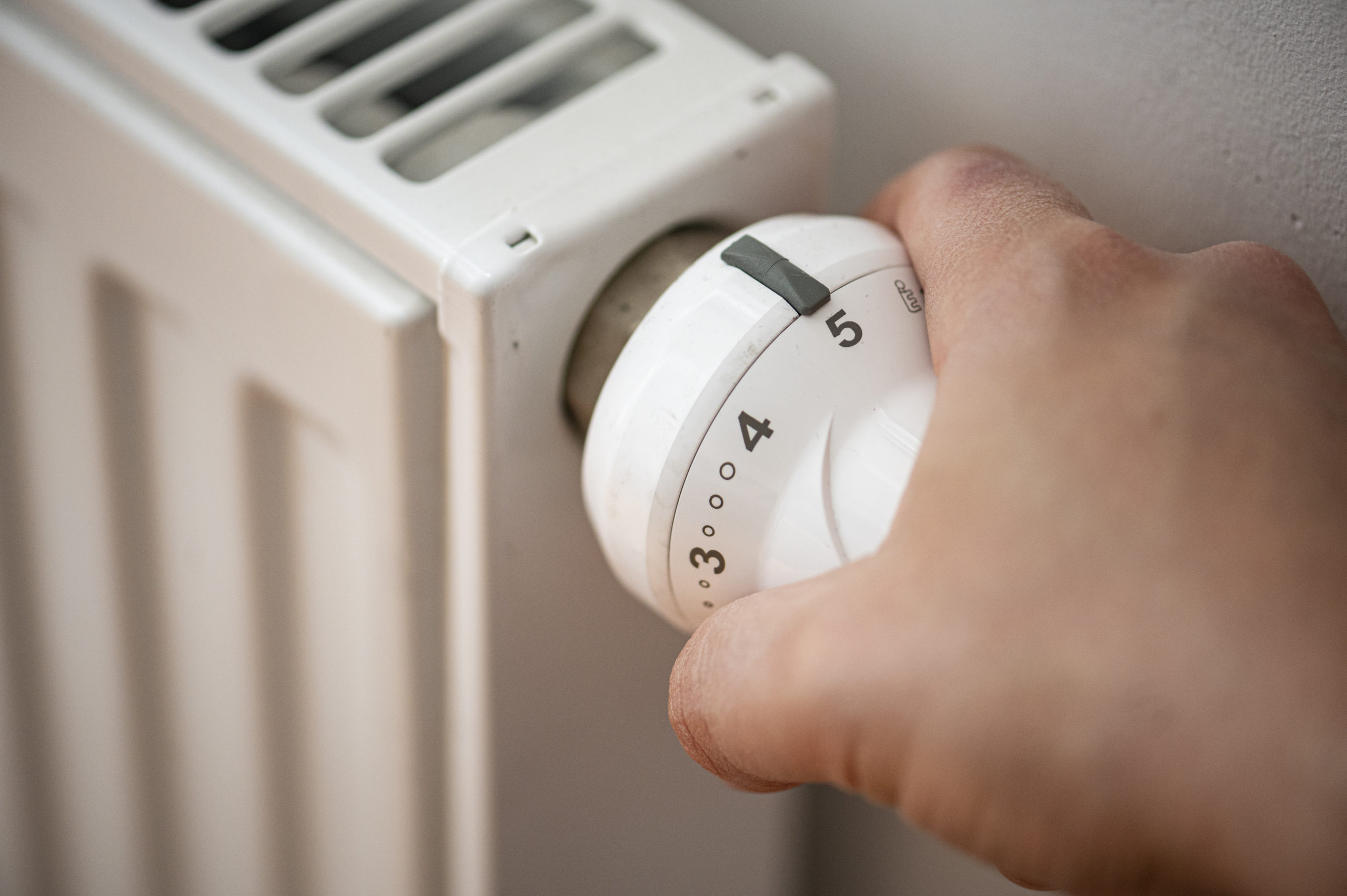 A man turns the radiator on