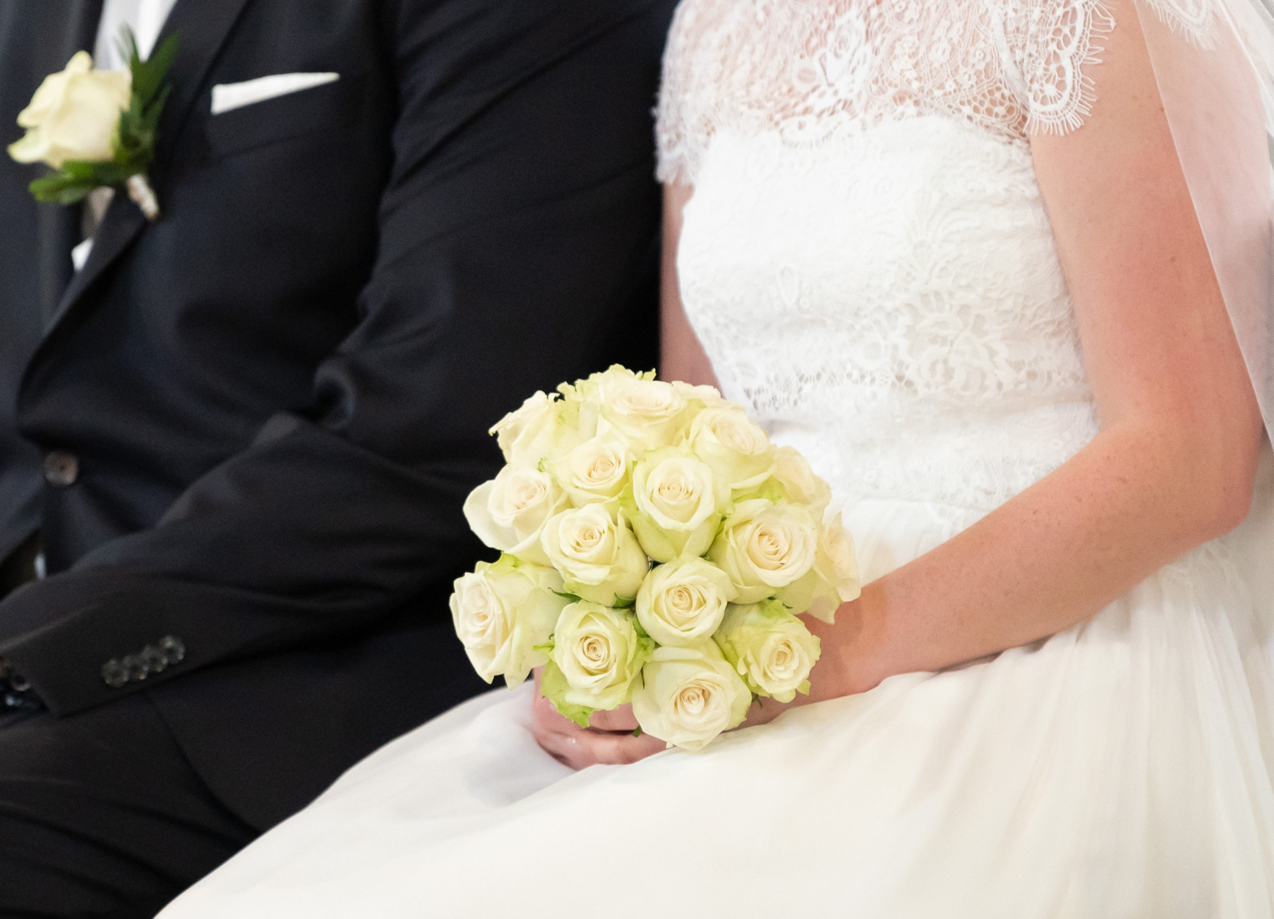 A bride and groom sit in a church at a German wedding in June 2021. 