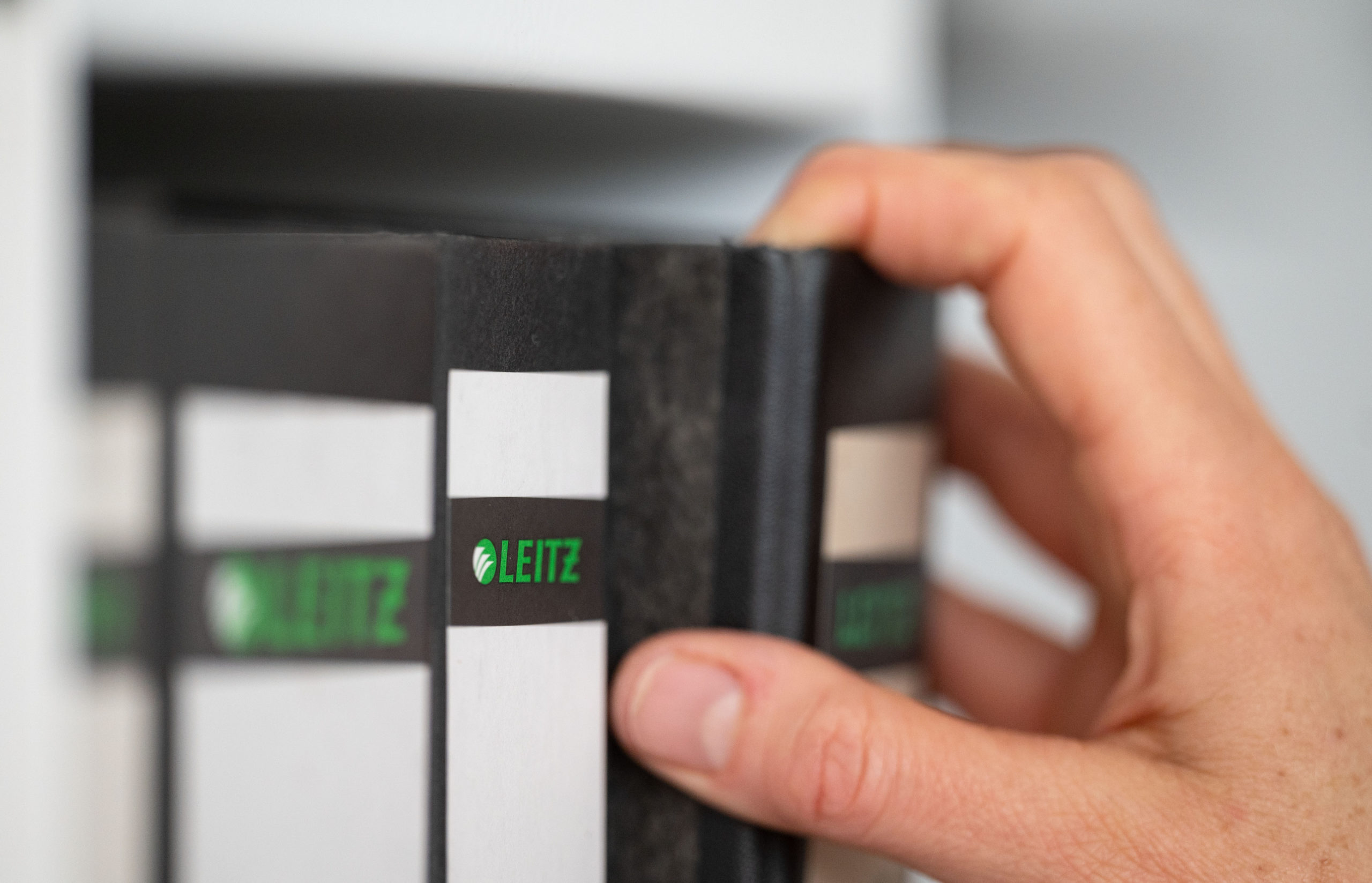 A woman takes a folder from a shelf.