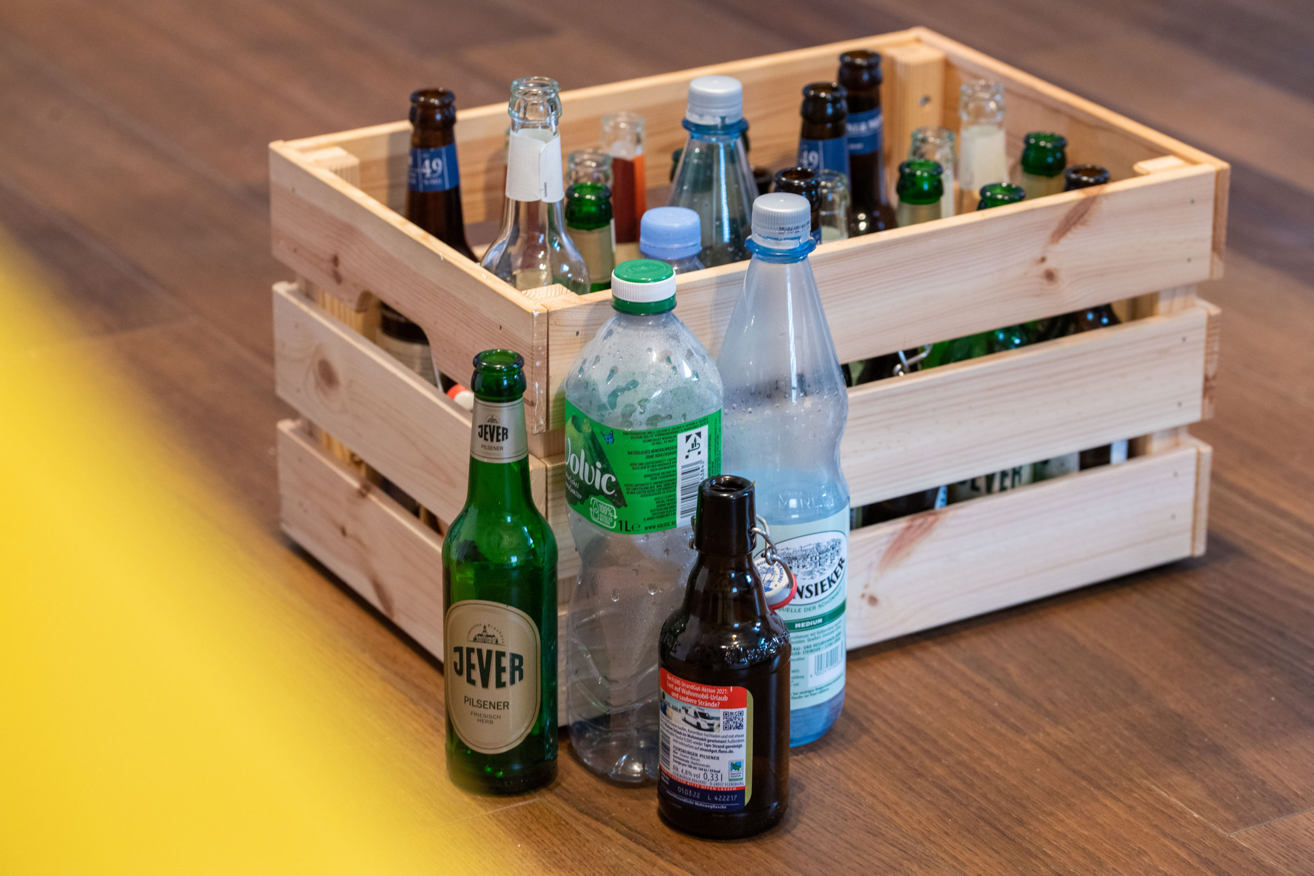 Various deposit bottles in front of and in a box on the floor.