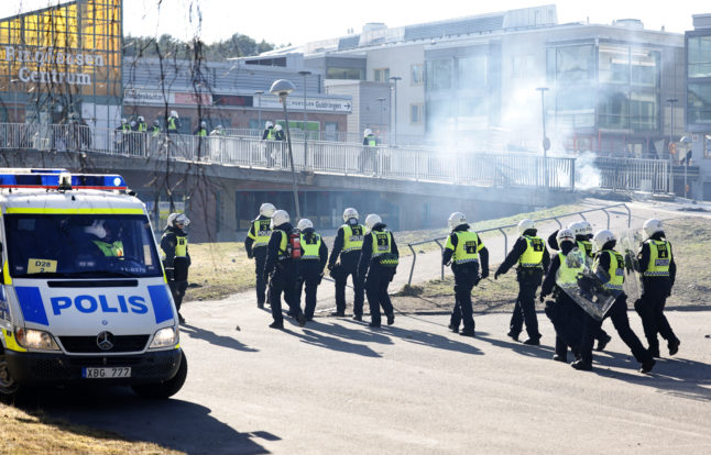 Riot-equipped police pass a barricade at the centre of Ringdansen during the riots in Navestad in Norrköping on Easter day.