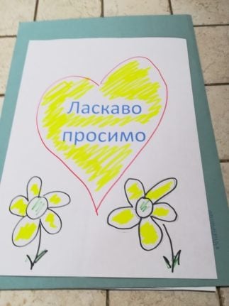 A sign made to greet the Ukrainian families at the bus stop in Lamezia reads 'Welcome' in Ukrainian.