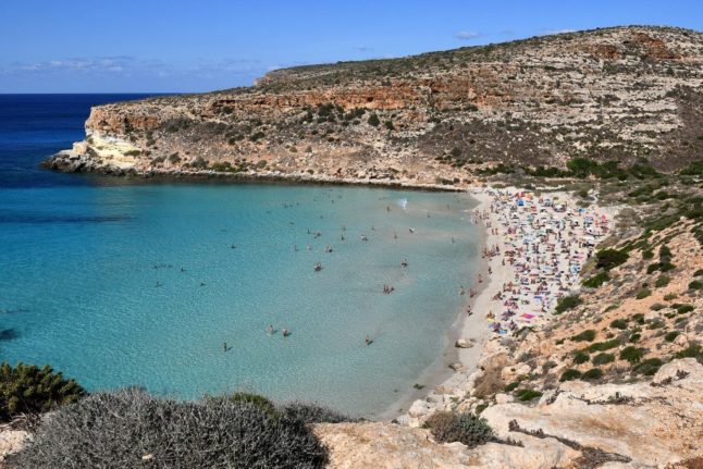 Tourists at the beach on Rabbit Island in Lampedusa, Sicily.