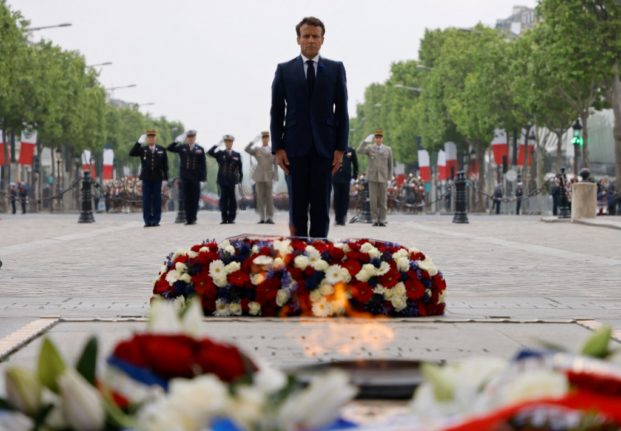 France's President Emmanuel Macron lays a wreath of flowers on the tomb of the unknown soldier at the Arc de Triomphe in Paris.