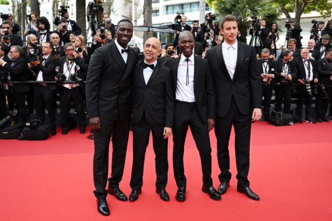 French actor and comedian Omar Sy, French director Mathieu Vadepied, actor Alassane Diong and French actor Jonas Bloquet pose as they arrive for the screening of the film 