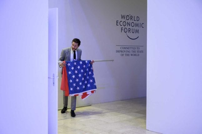 A person carries a Chinese and an American flag at the 2022 World Economic Forum in Davos. Image: Fabrice COFFRINI / AFP