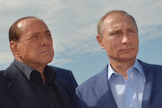 Russian President Vladimir Putin and former Italian prime minister Silvio Berlusconi pose for a photo.