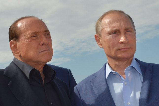 Russian President Vladimir Putin and former Italian prime minister Silvio Berlusconi pose for a photo.