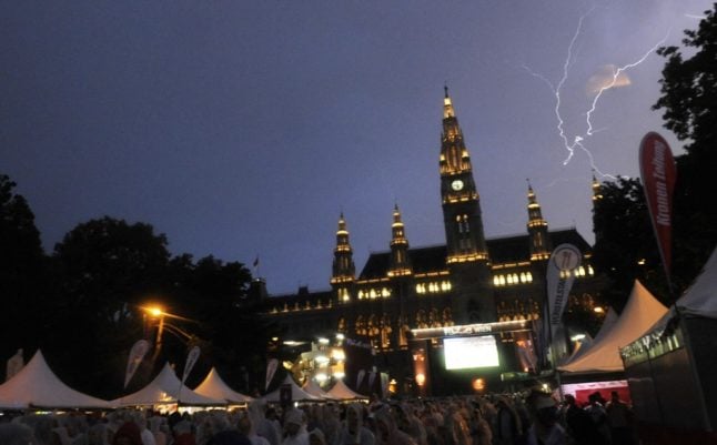 Lightning strikes in front of the Rathaus square (Photo by SAMUEL KUBANI / AFP)