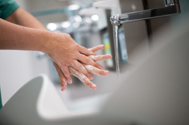 A woman washes her hands at a clinic in Essen