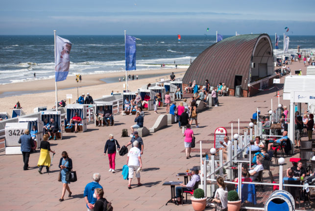 People walk along the promenade on the beach in Westerland on the North Sea island of Sylt in June 2021.