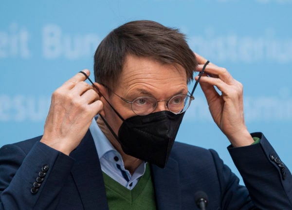 Karl Lauterbach (SPD), Federal Minister of Health, puts his mask back on after a press conference.