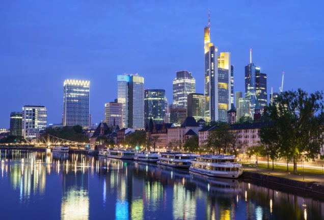 Frankfurt's banking skyline reflected in the Main river in the early morning light.