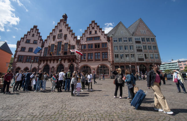 Passers-by and tourists walk across Römerberg in Frankfurt.