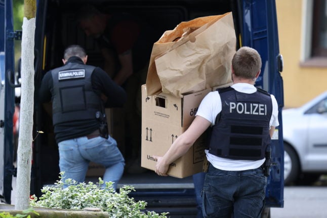 Police officers carry objects out of the 16-year-old suspect's home in Essen.