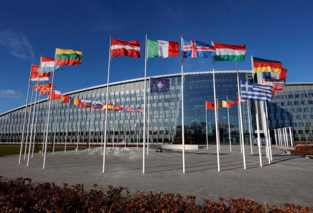 Flags flutter in the wind outside NATO headquarters in Brussels, Feb. 7th, 2022.