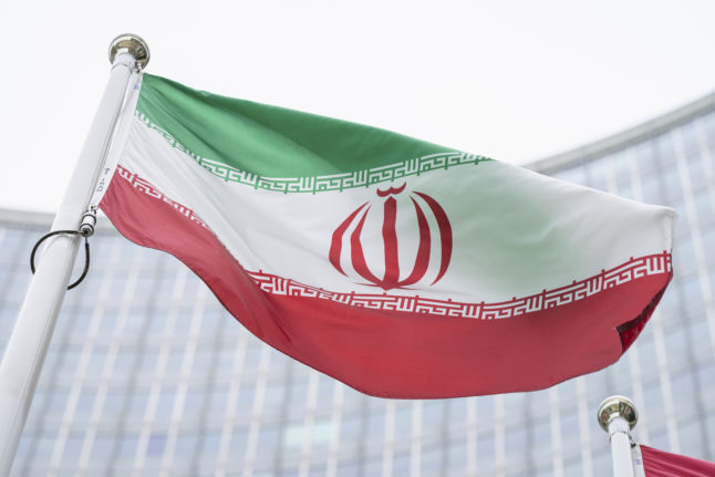 The flag of Iran waves in front of the the International Center building in Vienna, Austria.