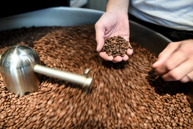 A cafe worker holds coffee beans in Kaffee9, Berlin.