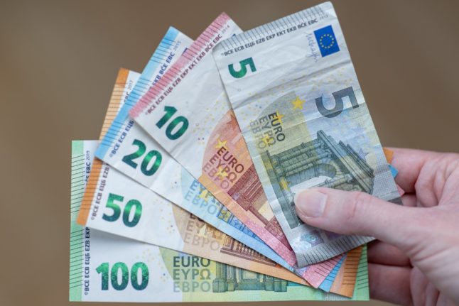 A woman in Germany holds cash notes in her hand.