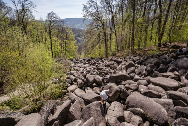 Visitors climb over the large rocks of the Felsenmeer.