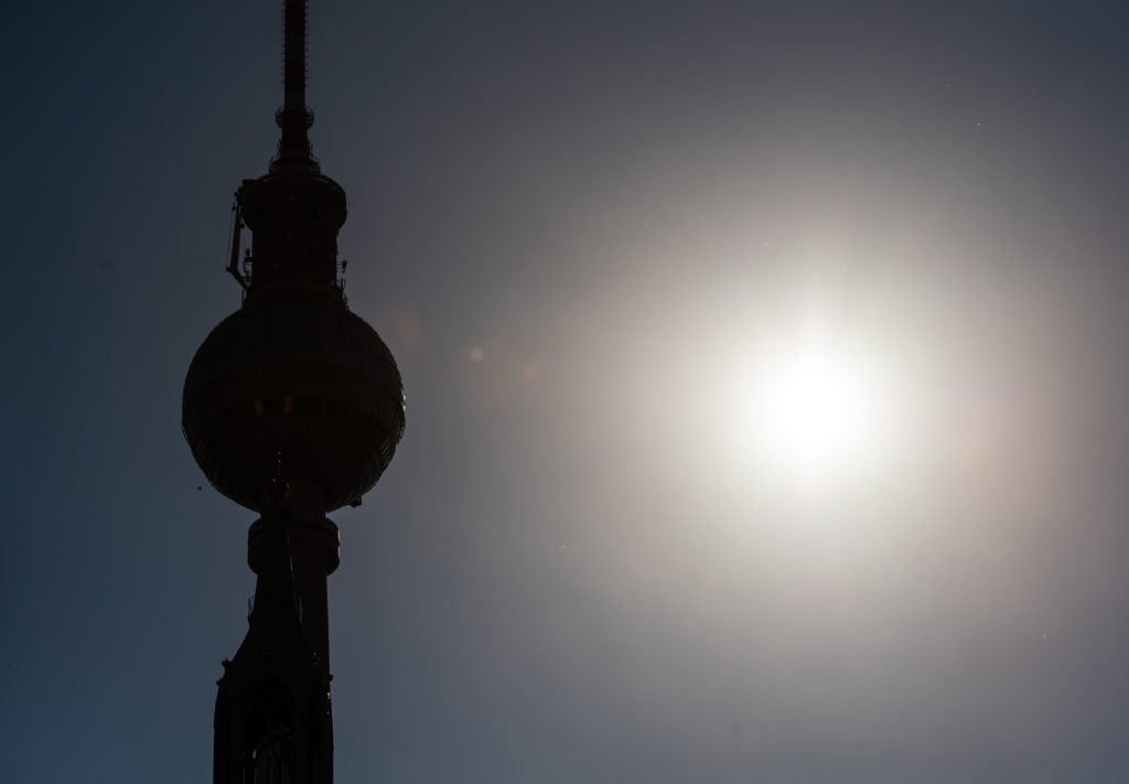 The sun shining next to the TV Tower in Berlin's Alexanderplatz. 