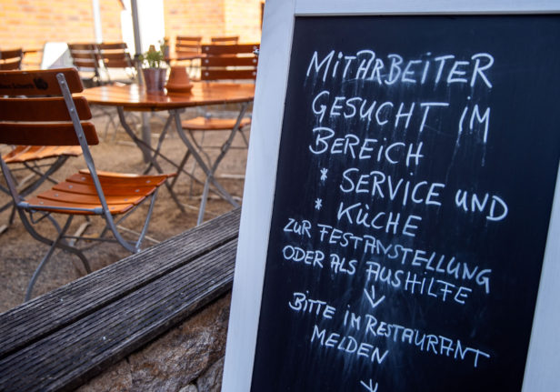 A notice board in front says a restaurant in Schwerin is looking for staff in the service and kitchen areas.