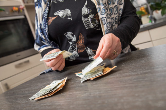 Person counting money in a kitchen