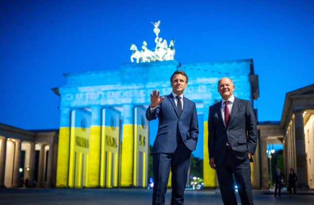 German Chancellor Olaf Scholz and French President Emmanuel Macron at Berlin's Brandenburg Gate lit up in the colours of the Ukraine flag in May.