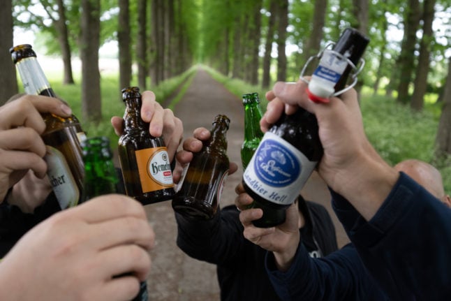 A group of friends clink beers in Leer, Lower Saxony.